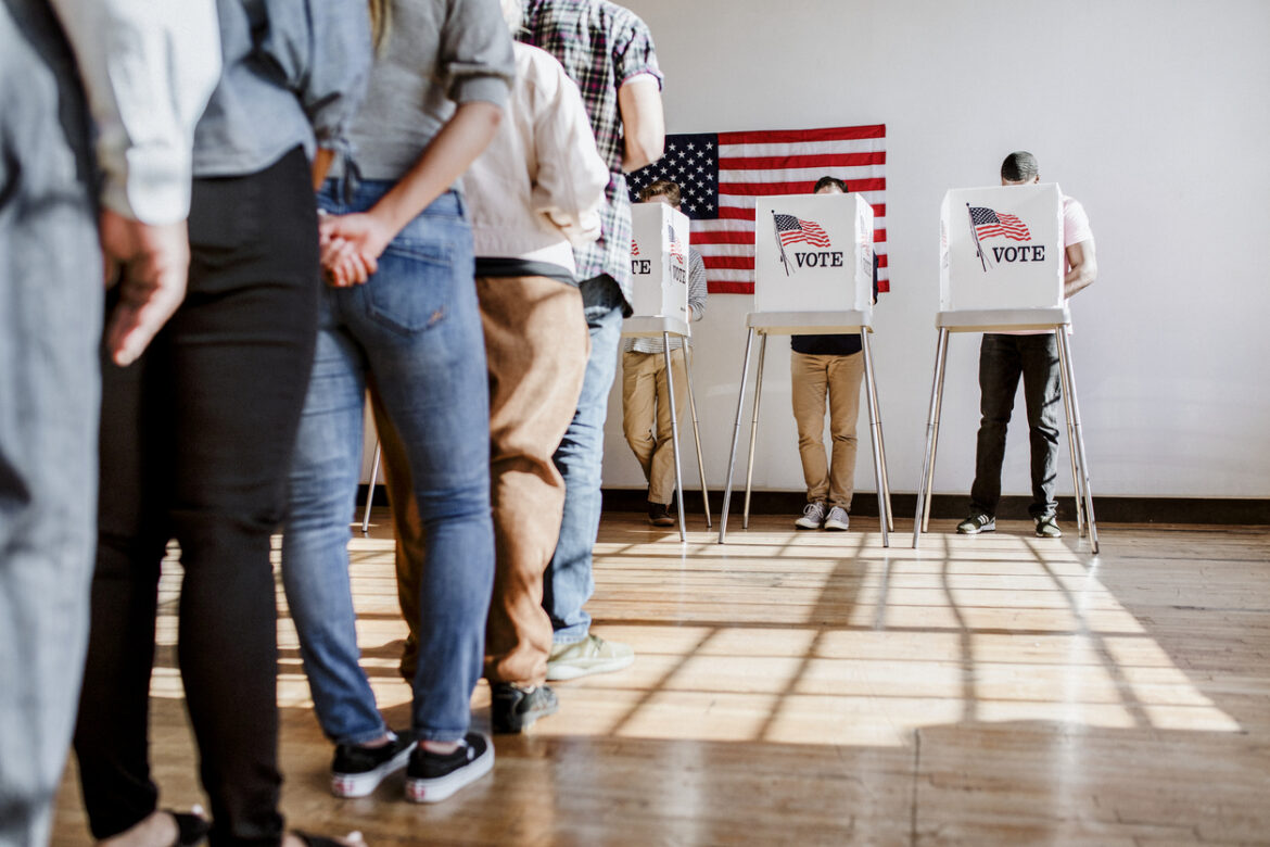 Image of a polling station with a line of people waiting to vote