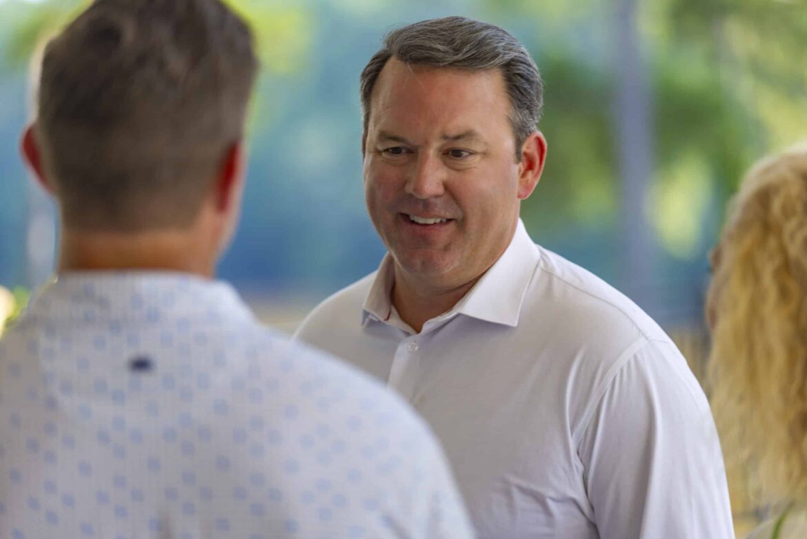 Lt. Gov. Burt Jones talking with an unidentified man and woman.