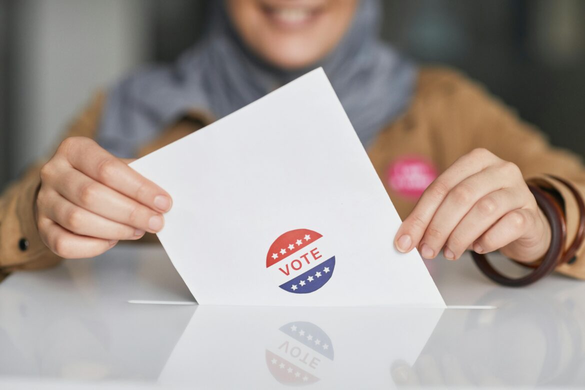 A woman placing her ballot into the ballot box.