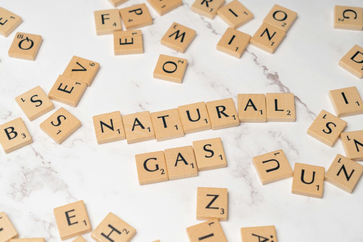 Scrabble peices on a white background spelling, "natural gas."