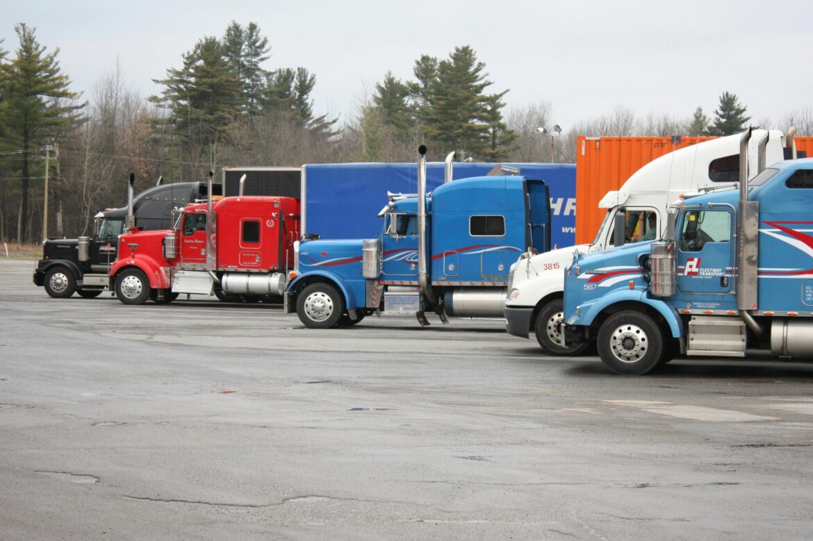 A line of trucks sitting in a parking lot.