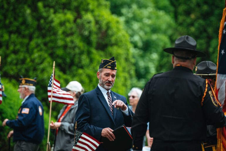 veterans in uniform and U.S. flags