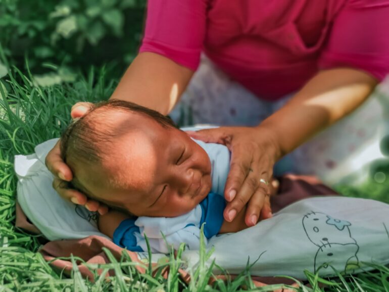 An infant being set down gently on a blanket