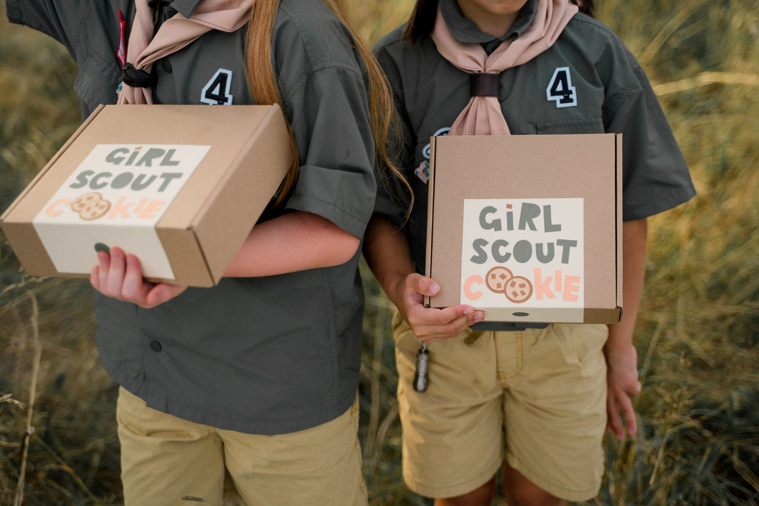 Two Girls Scouts hold boxes of cookies